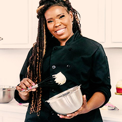 Lakisha Morris standing in a kitchen with a mixing bowl and whisk