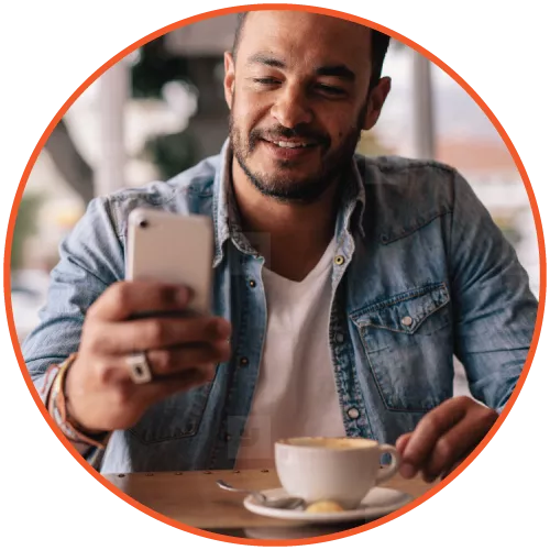 Man using a smartphone and enjoying a cup of coffee