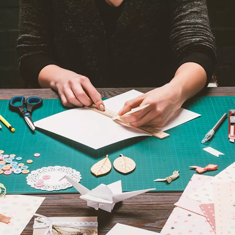 Person making a card on an art mat