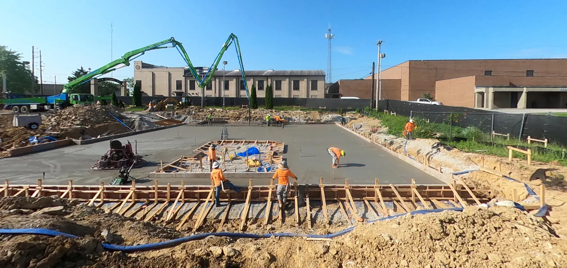 Construction workers and equipment pouring concrete