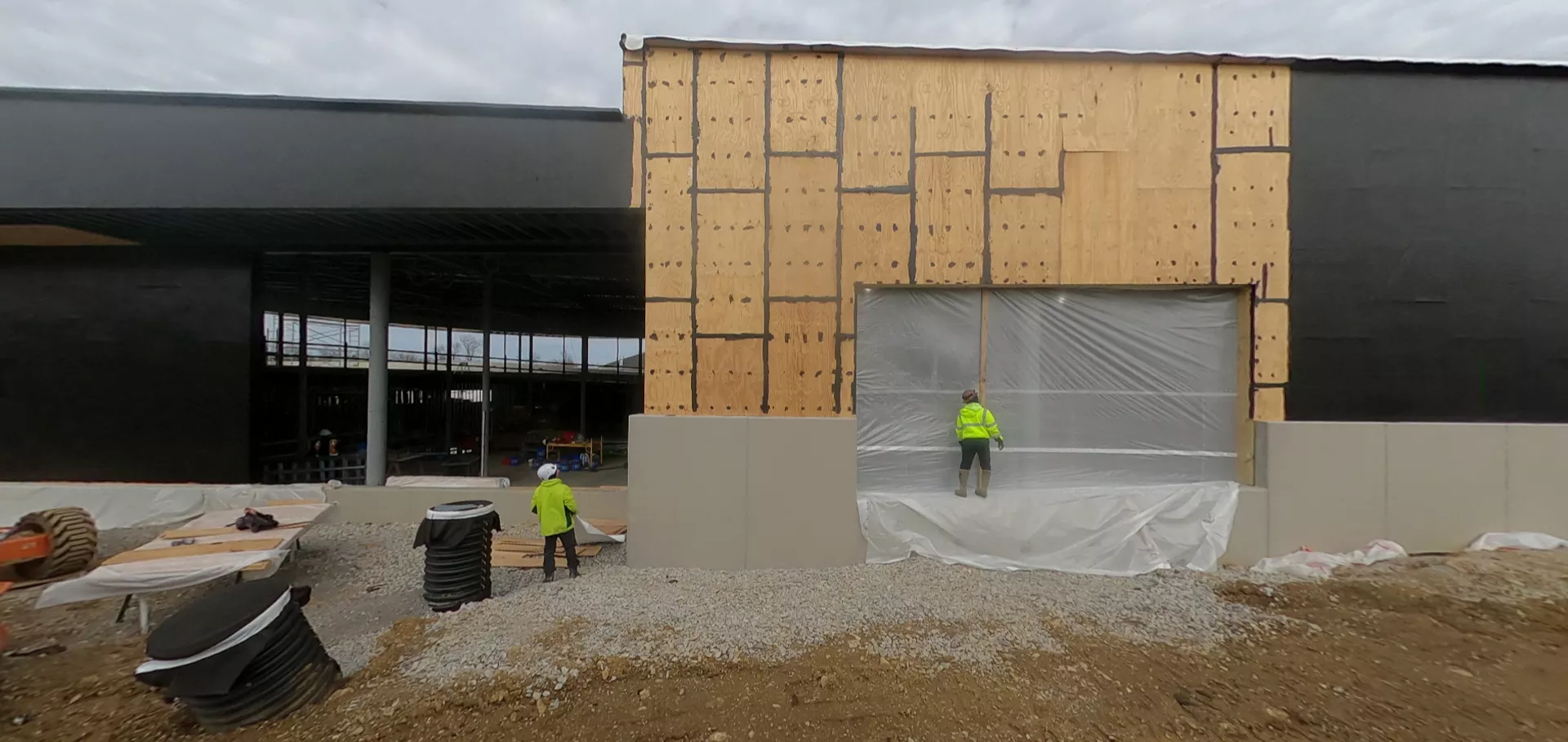 Construction workers examining a side wall and window opening