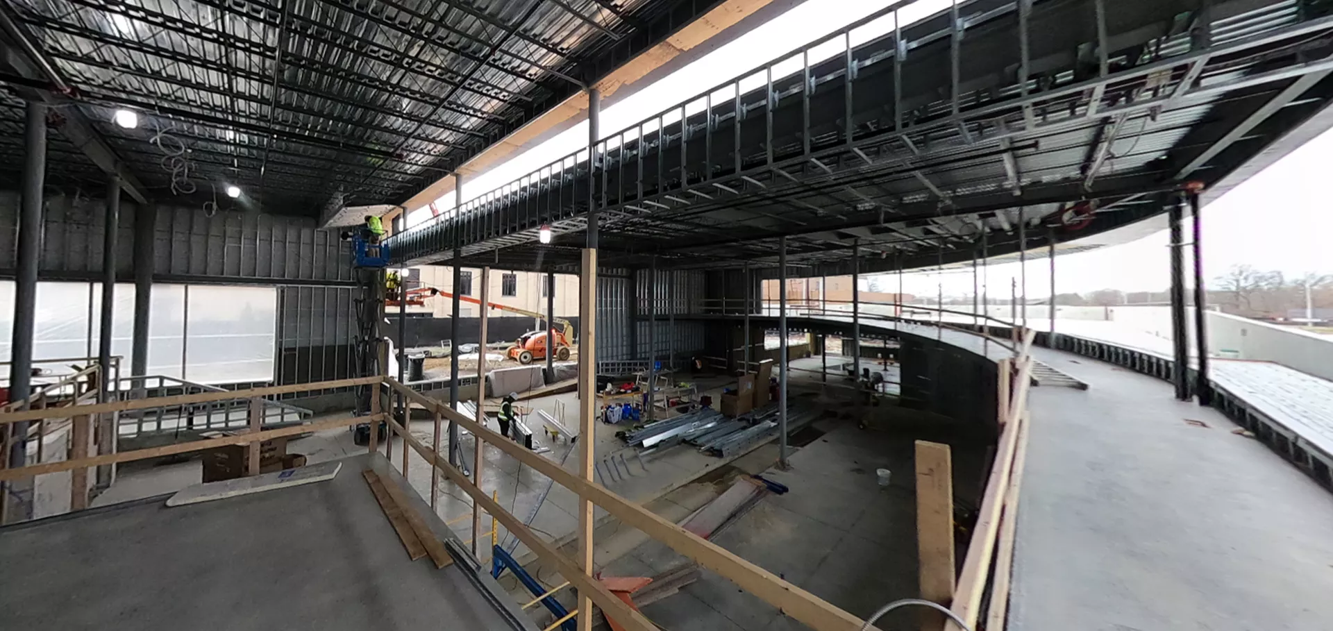 Internal view of upper and lower levels while construction workers work on a section
