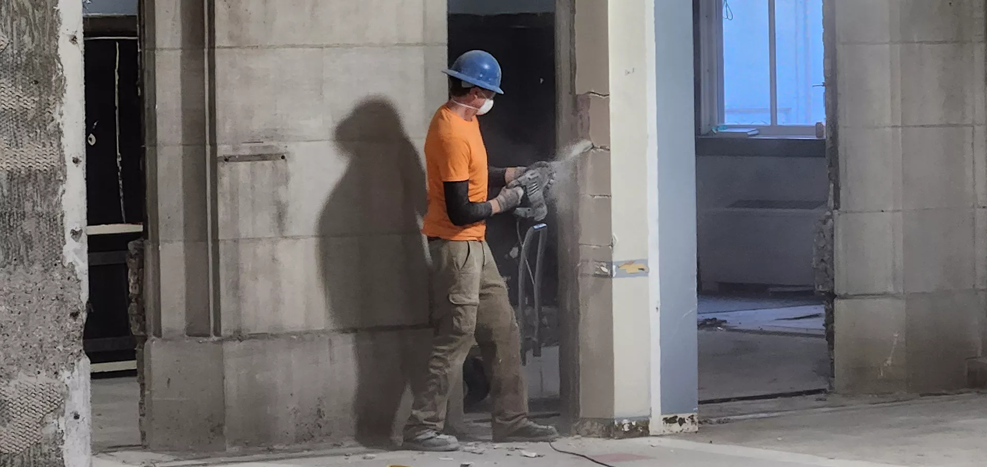 Construction worker drilling into a post