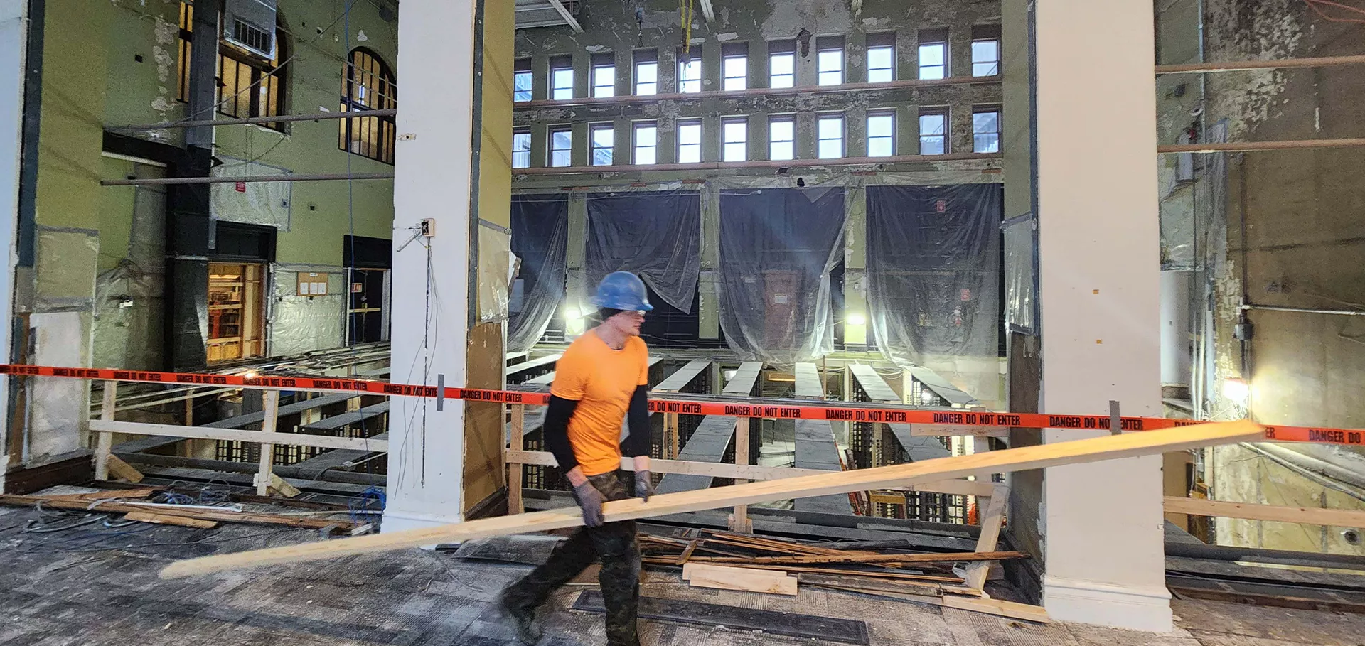 Construction work carrying materials in front of open library stacks
