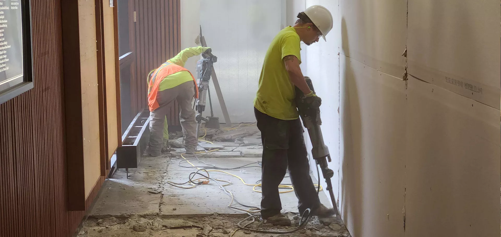 Construction workers jackhammering the floor