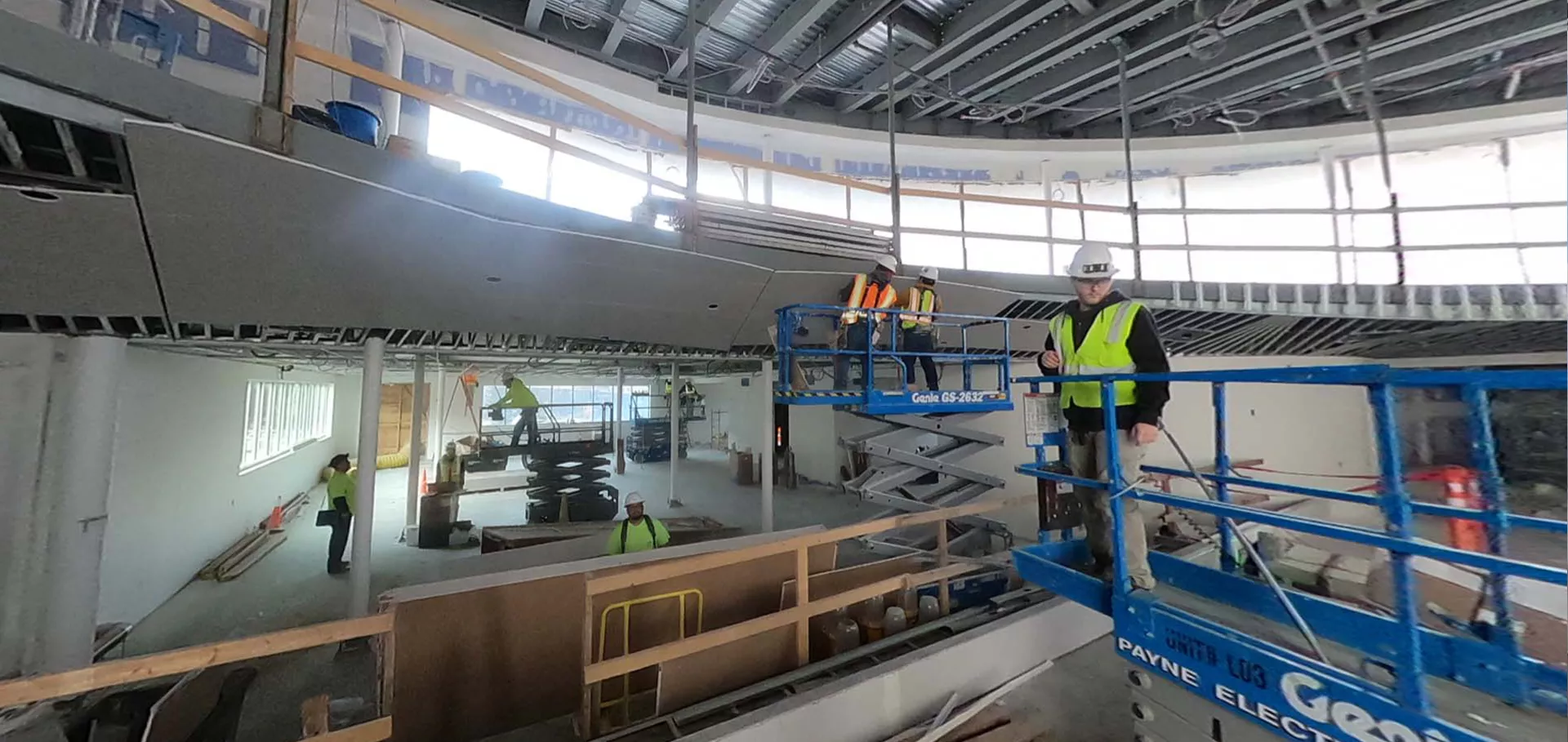 Construciton workers inspecing while on scissor lifts
