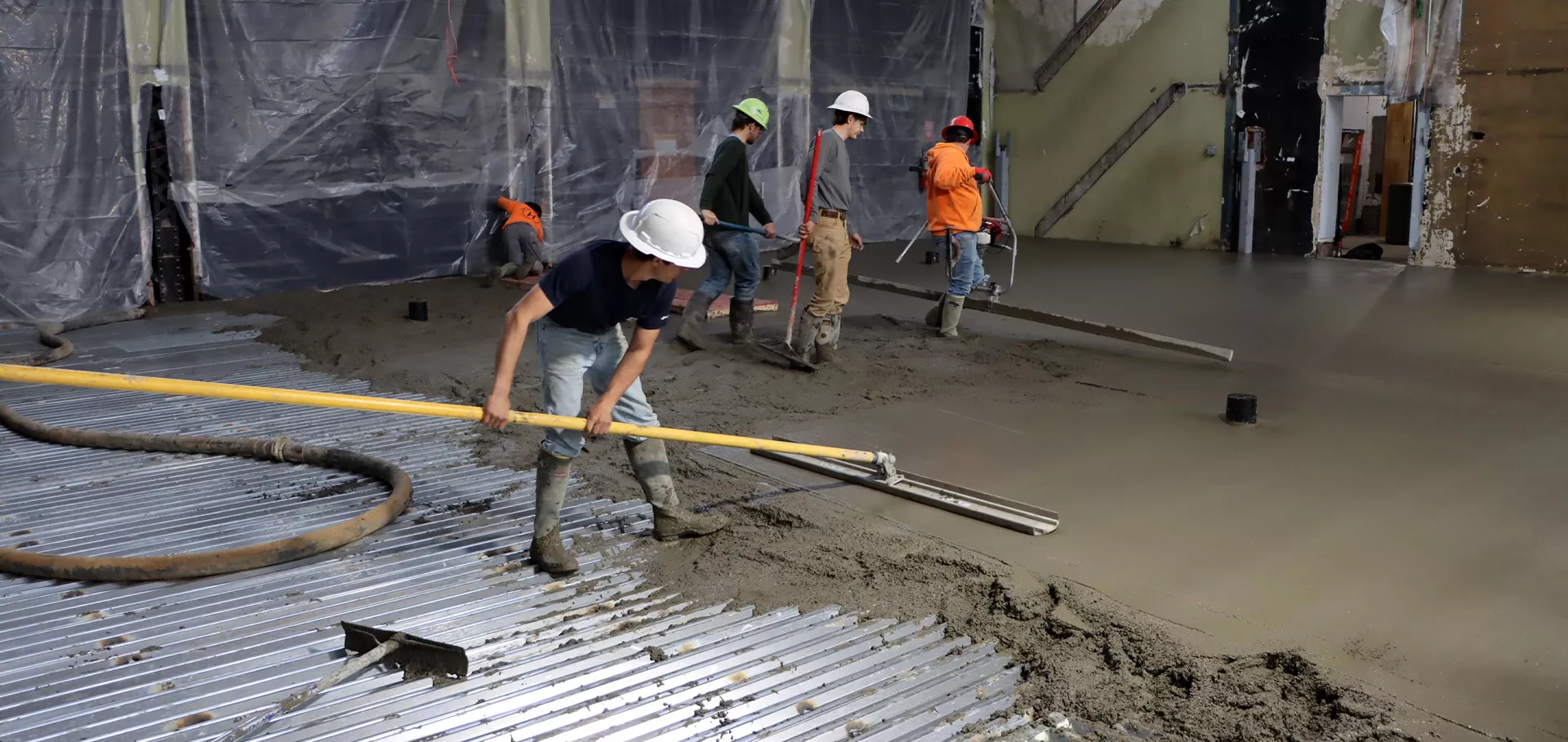 Worker spreading concrete on the floor